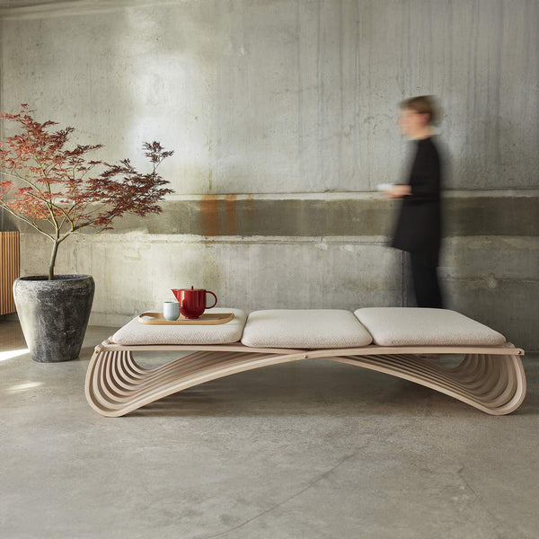 Daybed with three cushions, placed next to concrete wall