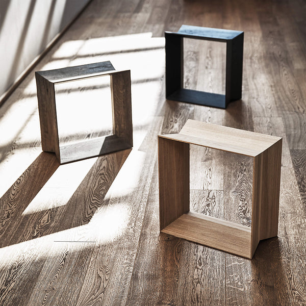 Set of three oak stools placed on a wooden floor