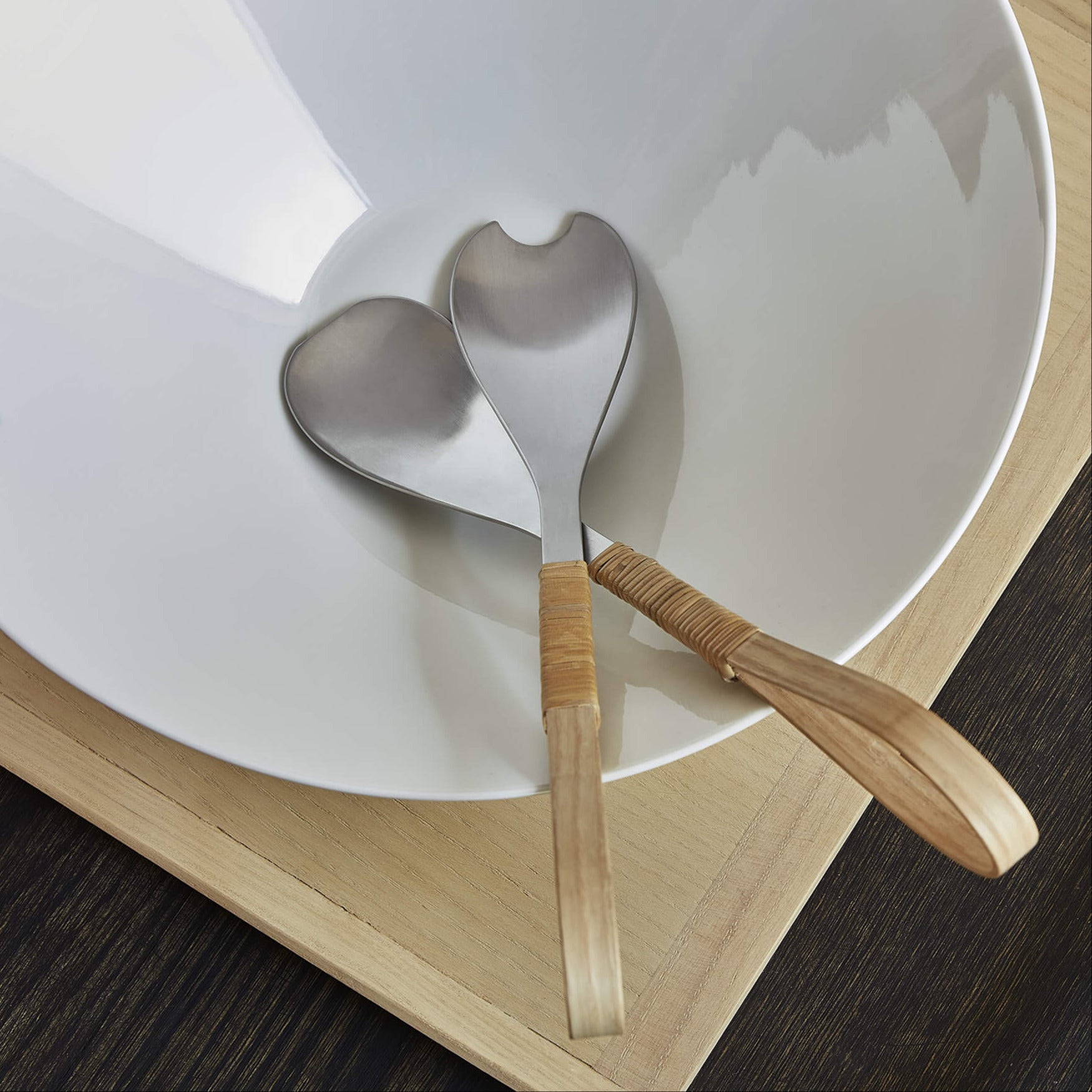 Top view of a porcelain bowl containing salad cutlery