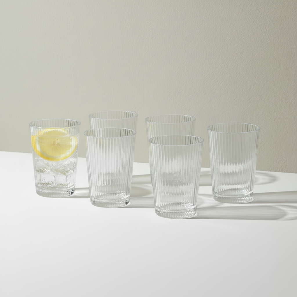 Six Pilastro glasses with one filled with lemon water