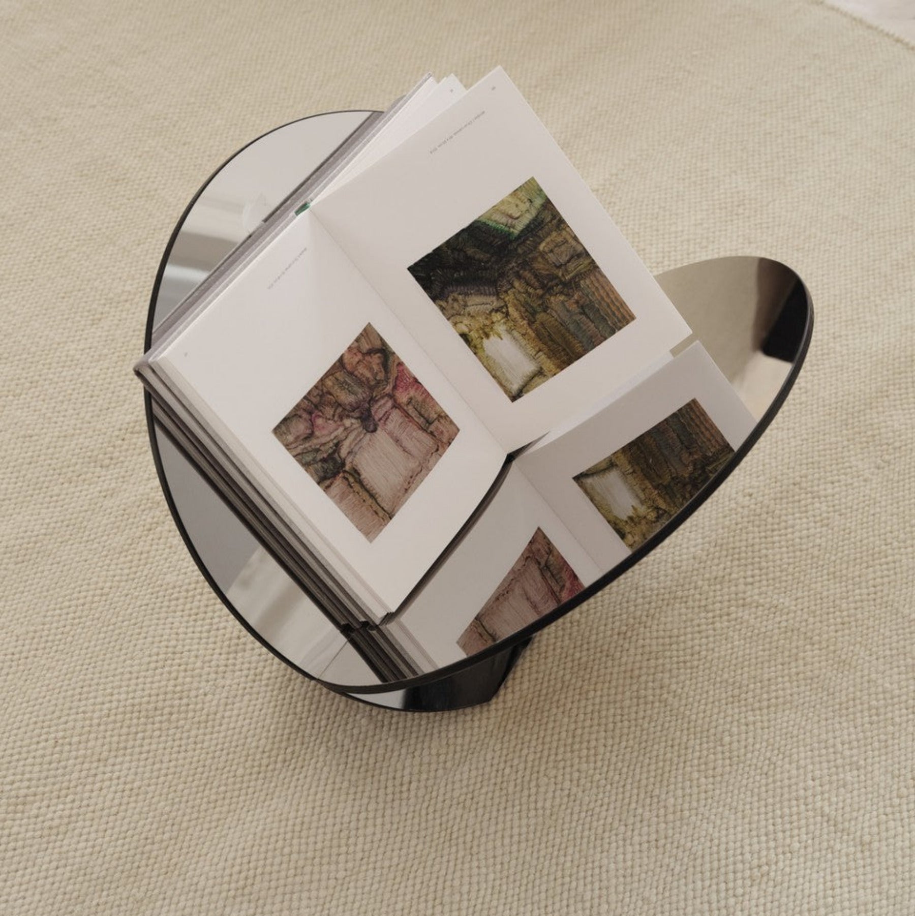 Stainless steel edgy minimalist magazine rack/storage with modern reflective surface.