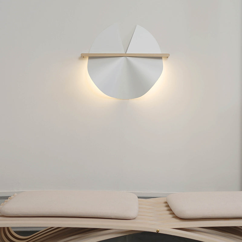 Unfolded wall lamp with lights on, placed above a daybed