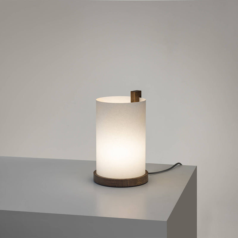 Small table lamp with light on, and a dark brown frame