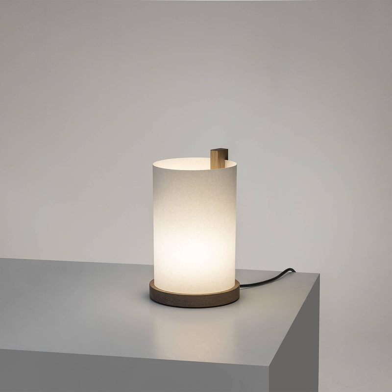 Paper table lamp with light on, and a light brown frame