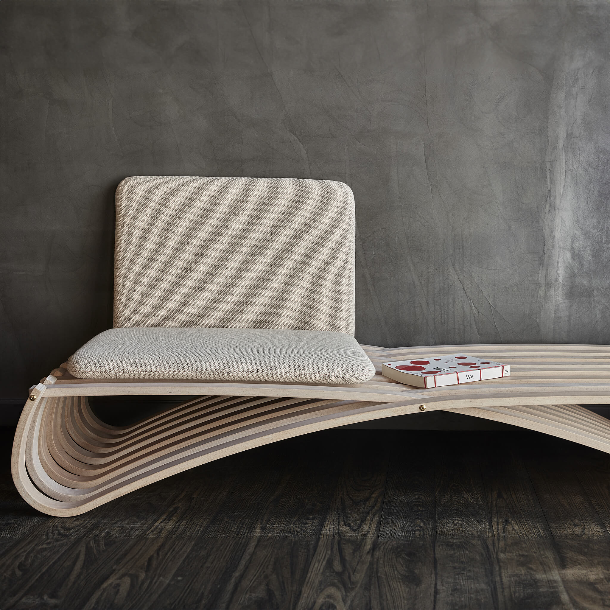 Daybed with two cushions, where one stands against the wall