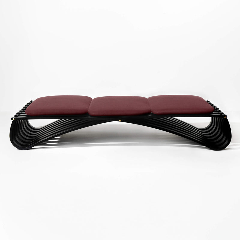 Black wooden daybed with three dark red textile cushions, front view