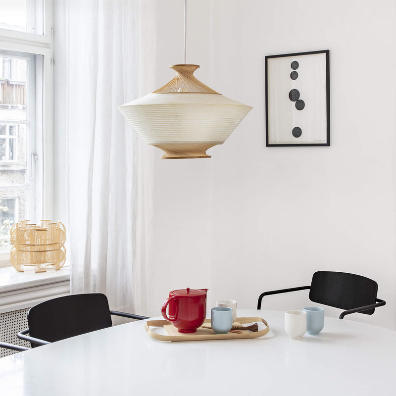 Pendant light made of paper and bamboo, placed above the dining table
