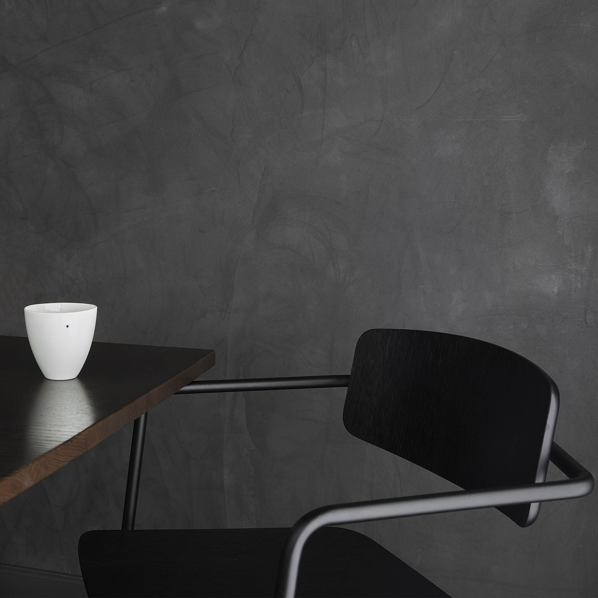 One porcelain bowl placed on a wooden table, next to a dining chair