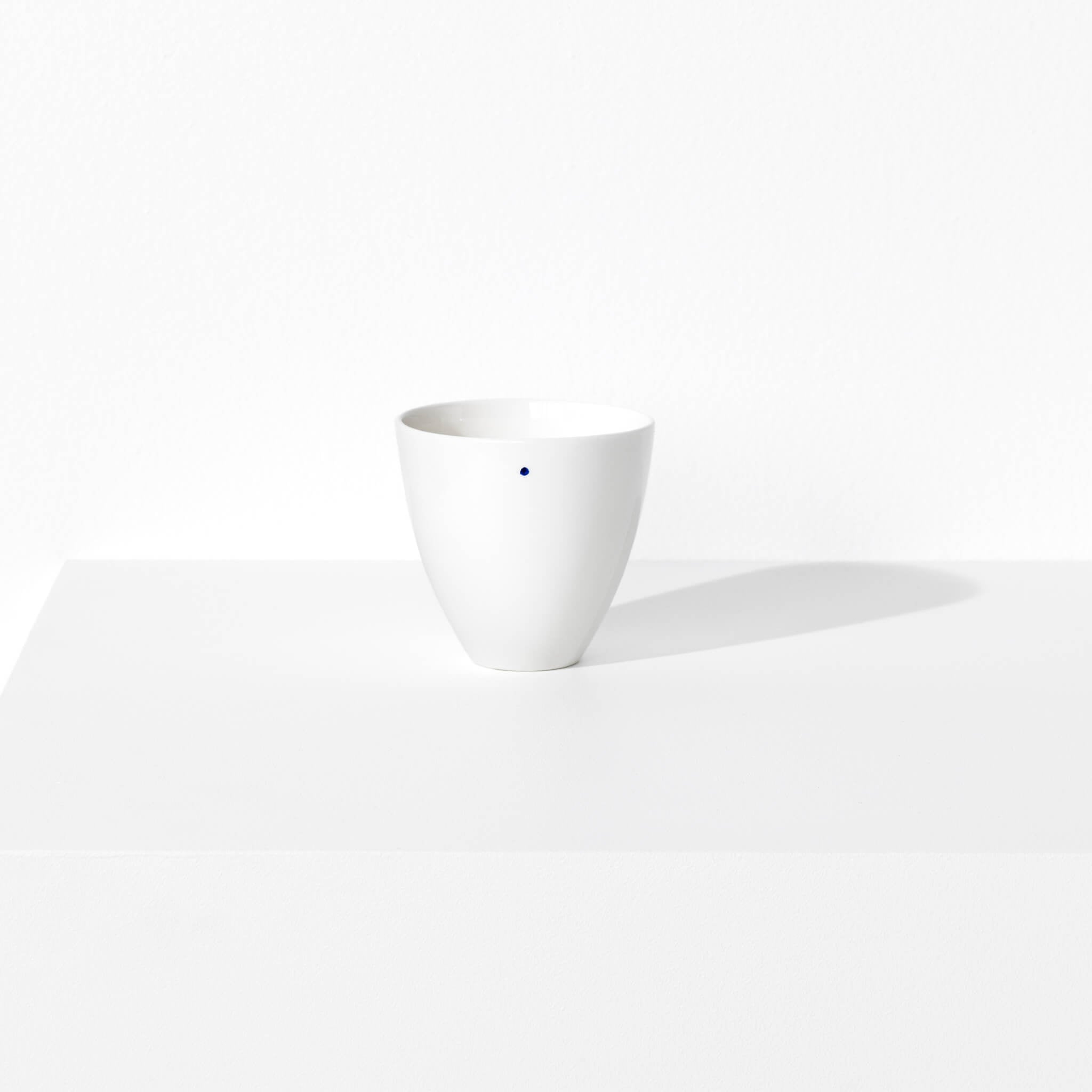 Small porcelain bowl featuring a design with one blue indigo dot