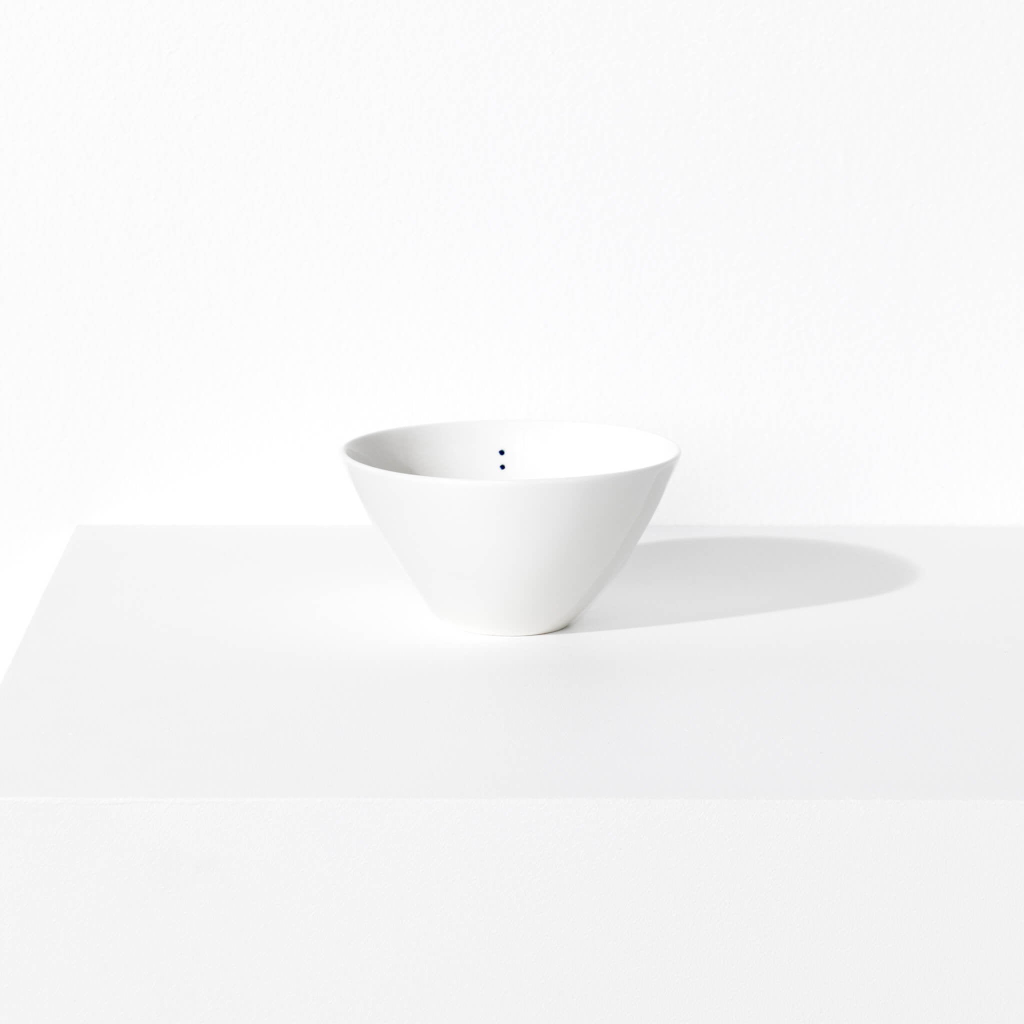 Small porcelain bowl featuring a design with two blue indigo dots