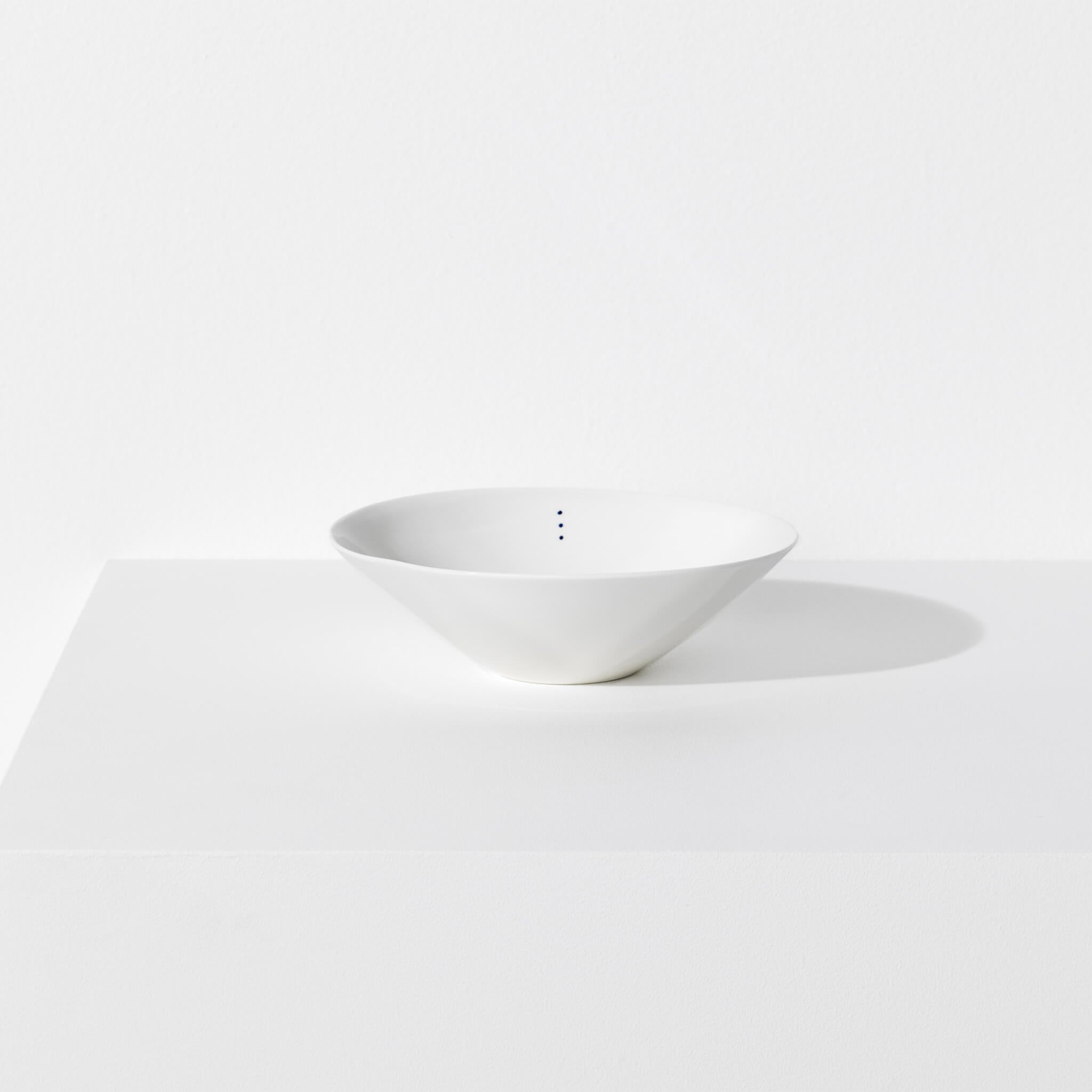 Small porcelain bowl featuring a design with three blue indigo dots