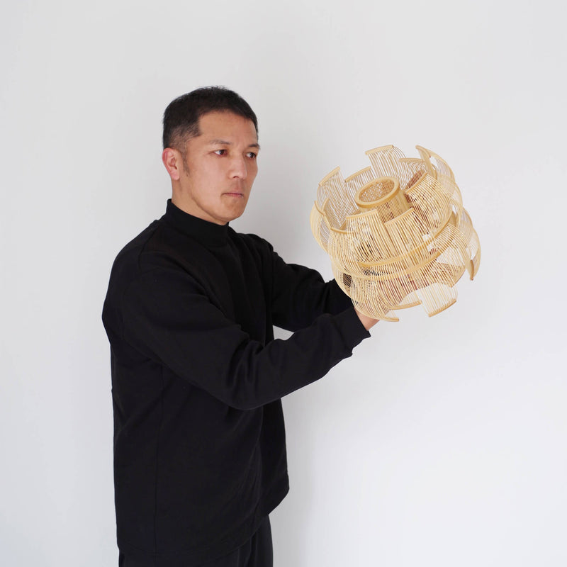 Designer holding the bamboo table lamp in his hands