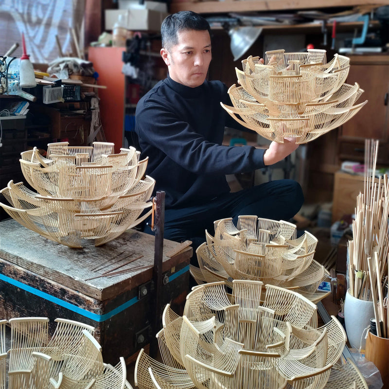 Designer crafting the bamboo pendant light in his studio