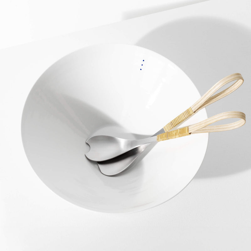 Top view of salad cutlery placed inside a large porcelain bowl