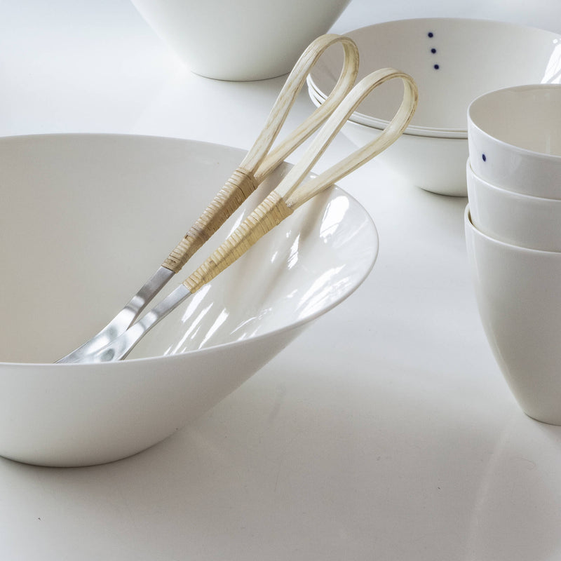 Salad cutlery placed in a porcelain bowl, side view