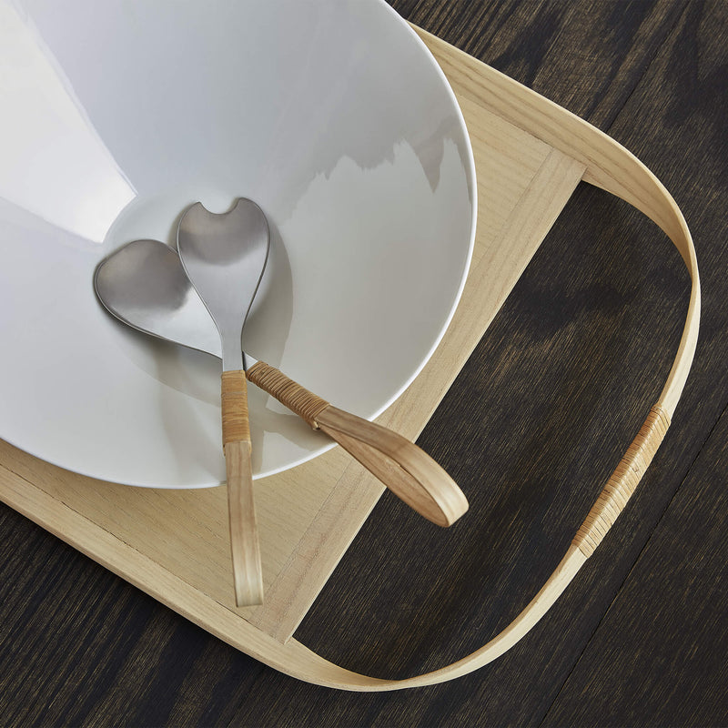 Stainless steel salad cutlery placed in a porcelain bowl, top view