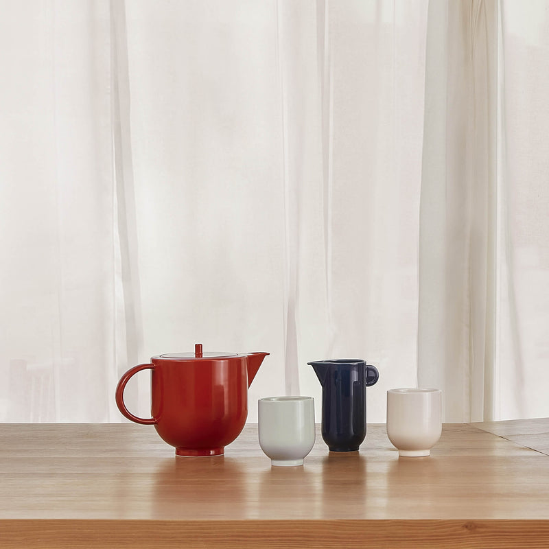 Porcelain tea set placed on a wooden counter top, side view