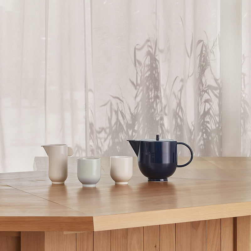 Tea set displaying a pitcher, two mugs and one teapot, side view