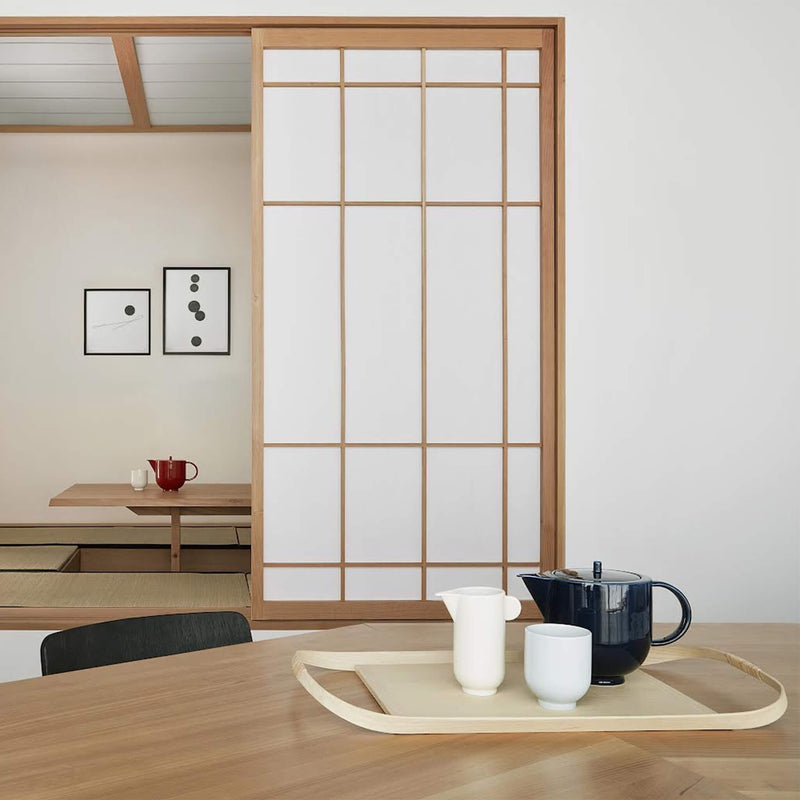 Tea set containing a mug, pitcher and teapot, placed on a wooden table